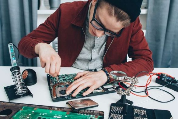 Un prestataire informatique répare minutieusement les composants d'un PC portable.